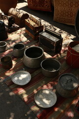 Old typewriter, sewing machine, accordions, and metal pots displayed at the Dry Bridge flea market in Tbilisi, Georgia. Vintage collectibles symbolizing heritage and craftsmanship.