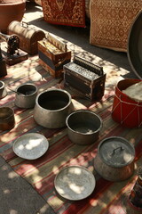 Old typewriter, sewing machine, accordions, and metal pots displayed at the Dry Bridge flea market in Tbilisi, Georgia. Vintage collectibles symbolizing heritage and craftsmanship.