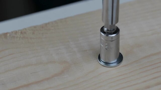 Close Up of Worker Tightening Nut with Screwdriver &ndash; Mechanical Repair, Maintenance, and Engineering Concept in 4K Ultra HD