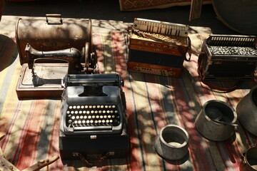 Old typewriter, sewing machine, accordions, and metal pots displayed at the Dry Bridge flea market...