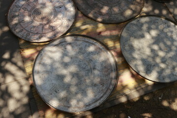 Antique copper trays and dishes with detailed engraving displayed at a flea market in Tbilisi. Warm...