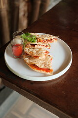 Delicious crispy flatbread stacked high with vibrant toppings and spicy sauce, perfect for sharing with friends or a tempting solo treat