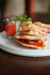 Delicious homemade quesadillas with tangy tomato sauce, perfect for a quick lunch or flavorful appetizer, ready to enjoy at a casual dining spot