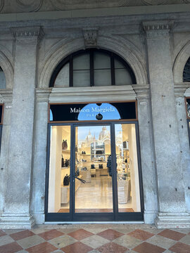 Venice, Italy - October 11, 2025: Maison Margiela storefront in Venice, showcasing luxury fashion items through glass doors, inviting shoppers to explore the elegant interior design