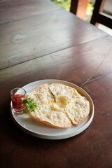 Enjoy delicious crispy quesadillas with a spicy dipping sauce at a rustic cafe, perfect for sharing and enjoying a flavorful meal, ideal for food bloggers