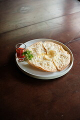 Delicious homemade quesadilla with melted cheese ready to eat on a rustic wooden table with vibrant fresh parsley garnish and zesty tomato sauce