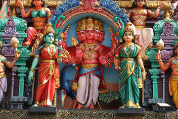 The six-headed Hindu god Kartikeya (Shanmukha) with spear and peacock as a colorful statue on temple exterior