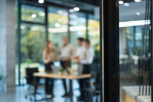 Businessmen blur in the workplace in office with computer or shallow depth of focus of abstract background, view from glass wall