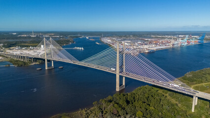 Aerial view of suspension bridge over the bay and shipping port in the background
