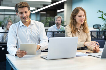 Obraz premium Happy young male customer support executive working in office.