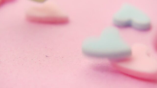 vibrant colorful sprinkles in heart shapes shower down on serene pink backdrop, evoking feelings of joy and celebration, concept St Valentine day