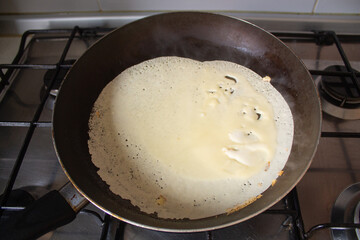 Homemade Pancake in Frying Pan on Gas Stove, First Crepe Cooking at Home, Real Kitchen Atmosphere