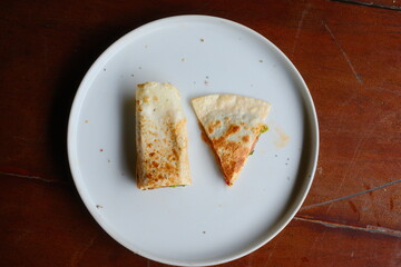 Enjoy a fresh, delicious chicken quesadilla cut and ready to eat on a modern white plate, perfect for a quick lunch or snack