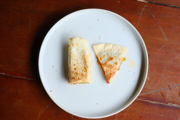 Delicious quesadilla sliced on a clean white plate, perfect for showcasing healthy lunches and quick meals with fresh ingredients on wooden table!