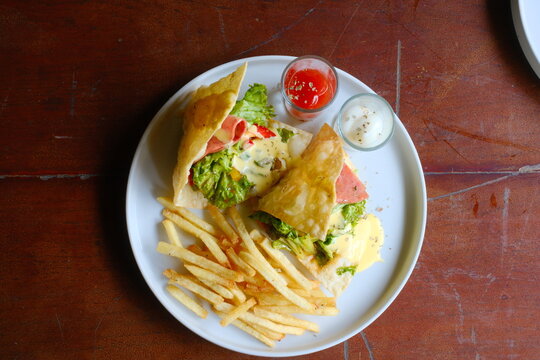 Enjoy a delicious wrap with fries, served with flavorful ketchup and cream sauce for a delightful meal, perfect for restaurant menus and food blogs!