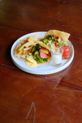 Delicious gourmet tacos served with crispy french fries and flavorful sauces, ready to enjoy for a satisfying and modern meal presentation