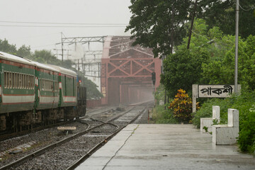 Obraz premium Green Train at Pakshi Railway Station on a Rainy Day