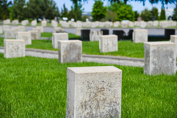 Stone tombstones standing upright on the green grass.