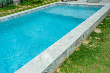 Empty swimming pool with sunbed and white umbrella in resort hotel for vacation leisure and white sand,resort neary sea and beach in summer.