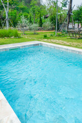 Empty swimming pool with sunbed and white umbrella in resort hotel for vacation leisure and white sand,resort neary sea and beach in summer.