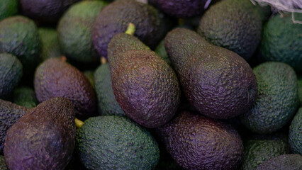 Close-up of fresh avocados arranged together, highlighting their rich texture and organic...