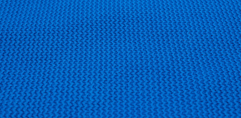 A macro texture of blue cotton jersey with a small repeating pattern. An ideal backdrop for presentations on design, fashion, sportswear, or the textile industry.