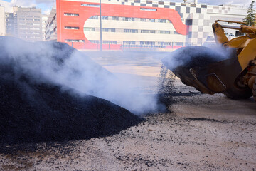 Heavy Machinery Loading Black Aggregate Material at the Construction Site for Development