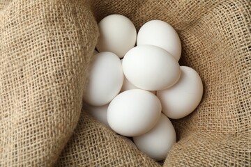 Many raw chicken eggs in sack, closeup