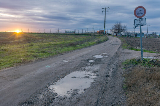 Atardecer en un camino rural con charcos en los campos de Fuenlabrada, Madrid, Espa&ntilde;a