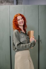 Fototapeta premium Smiling businesswoman holding documents standing in an office