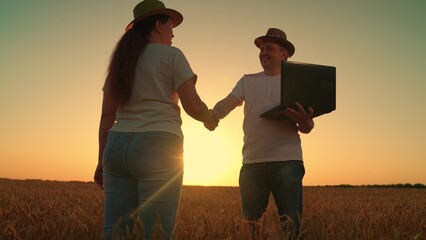 Farmers man woman, shaking hands in field, silhouette. Businesspeople shaking hands outdoors sun. Handshake teamwork. Teamwork business. Partners agreeing to deal, shaking hands as sign of agreement