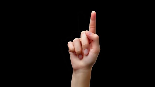 Solitary female hand displaying a finger-wagging motion to showcase disapproval or prohibition on a simple black backdrop. The gesture implies a sense of warning, scolding, or denial