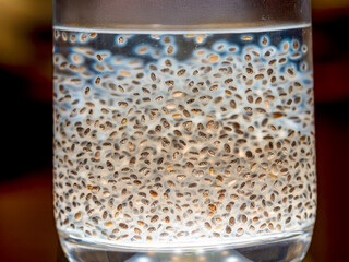 Macro photo of chia seeds floating in a glass of water. A healthy and natural drink rich in fiber, omega-3 fatty acids, and protein. Perfect image for topics related to healthy lifestyle, diet, superf