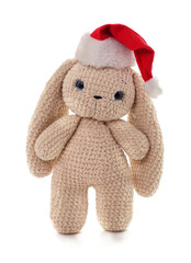 Knitted bunny toy wearing Santa hat on white background.
