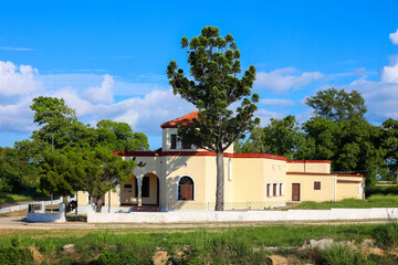 View of Che Guevara's house in Havana with red domed roof and tall tree on a sunny day