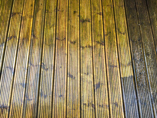 Before and after view of dirt and grime being cleaned from wooden decking using a pressure washer. DIY concept.