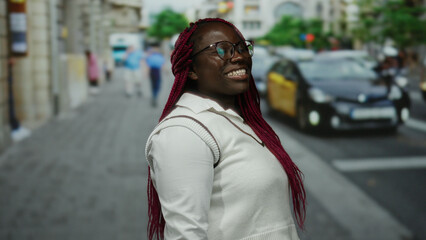 Obraz premium Woman smiling on city street with taxis and people in background, urban setting, depicting diverse culture and lively atmosphere on a sunny day.