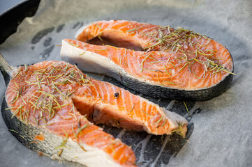Raw salmon steaks on a baking tray lined with parchment paper.