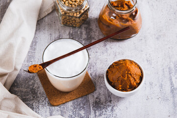 Miso-Spiked latte in a glass and a bowl of miso paste on the table