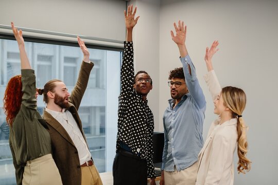 Business team raising hands participating in a meeting