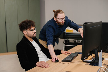 Diverse business professionals collaborating on computer screen discussing strategy