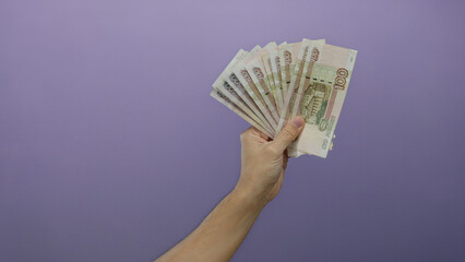 Man holding russian rubles against a purple background showcasing financial prosperity and business...