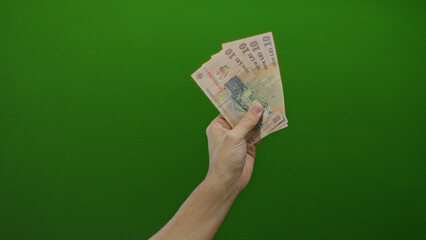 Hand holding romanian leu banknotes against a vibrant green background, showcasing currency with a...