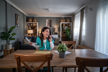 Nurse working from home, talking on phone, laughing