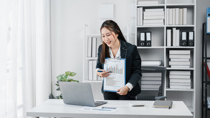 Asian Businesswoman Presentation Online Meeting with Data Chart on Clipboard in Office Workplace for Marketing Strategy and Financial Analysis Discussing Sales Target