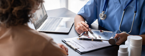 Asian doctor consultation with patient discussing medical information on laptop in clinic for healthcare treatment