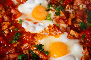 Shakshuka with eggs, tomatoes, and chicken pieces