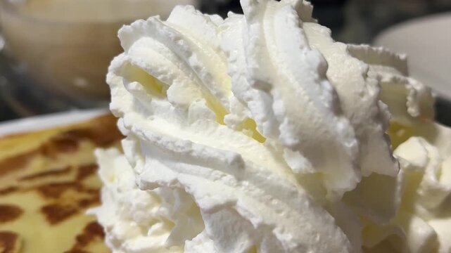 apply a lot of whipped white cream on a pancake close-up a lot of sweet sugar fructose glucose dairy products lactose