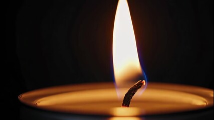 A close up of a candle flame burning brightly in the dark with a shallow depth of field view - Powered by Adobe