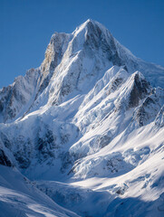 Majestic snow-covered mountain peaks illuminated by bright sunlight against clear blue skies in a pristine alpine winter landscape
